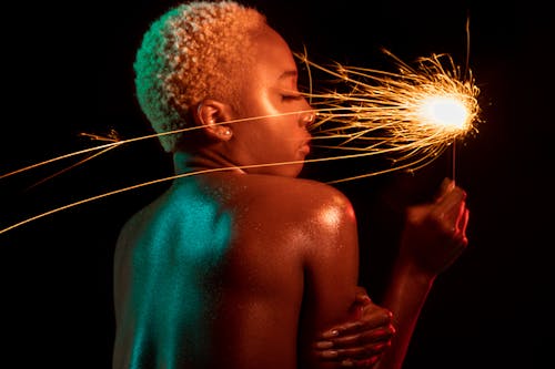 Free A Topless Woman Holding a Sparkler Stock Photo