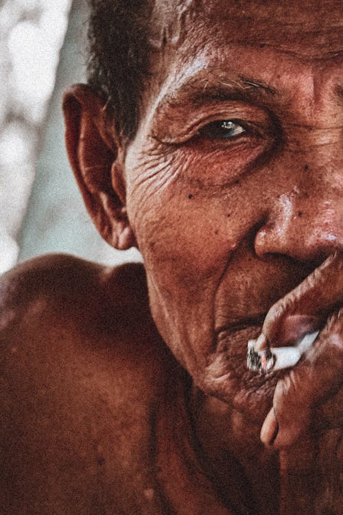 Close Up Photo of an Elderly Man Smoking Cigarette