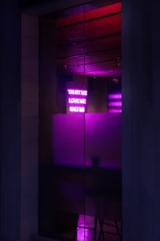 Stylish urban scene with purple neon signs glowing through glass at night.