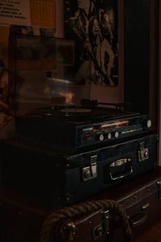 Retro turntable and vinyl records evoke nostalgia with vintage style in a dimly lit room.