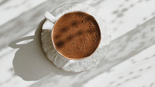 White Ceramic Mug on White Textile