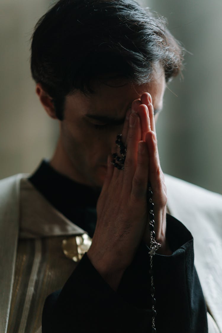 A Man Bowing Down His Head While Praying