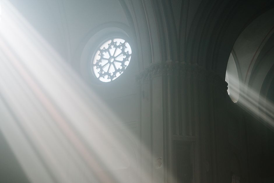 Sunlight streaming through a cathedral’s stained glass window creating a spiritual atmosphere