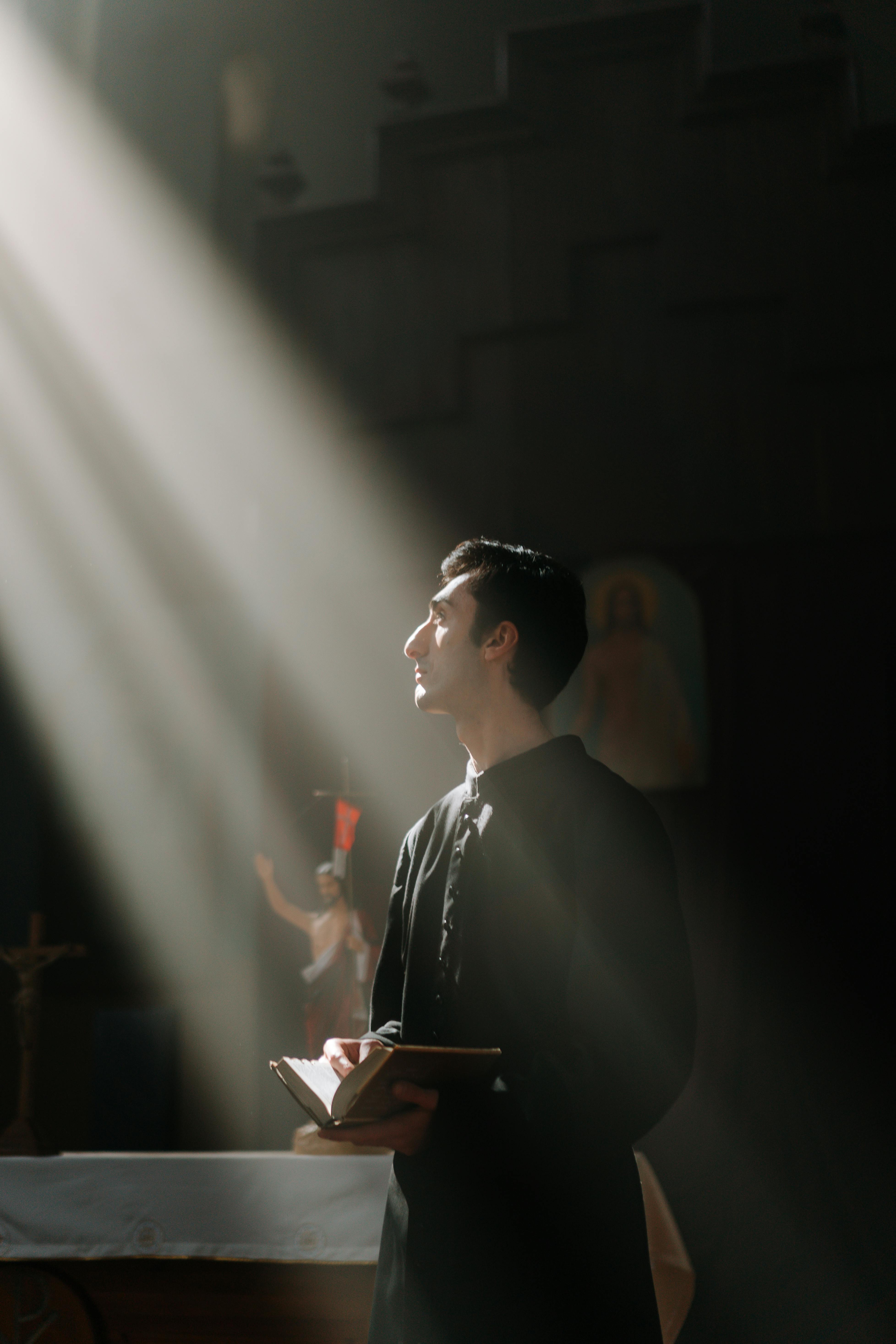 a priest in black vestment holding a bible