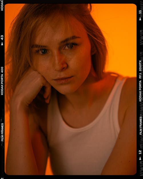 A Woman in White Tank Top with Her Hand on Face