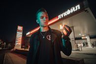 Man in Black Zip Up Jacket Standing Near Red and White Building during Nighttime