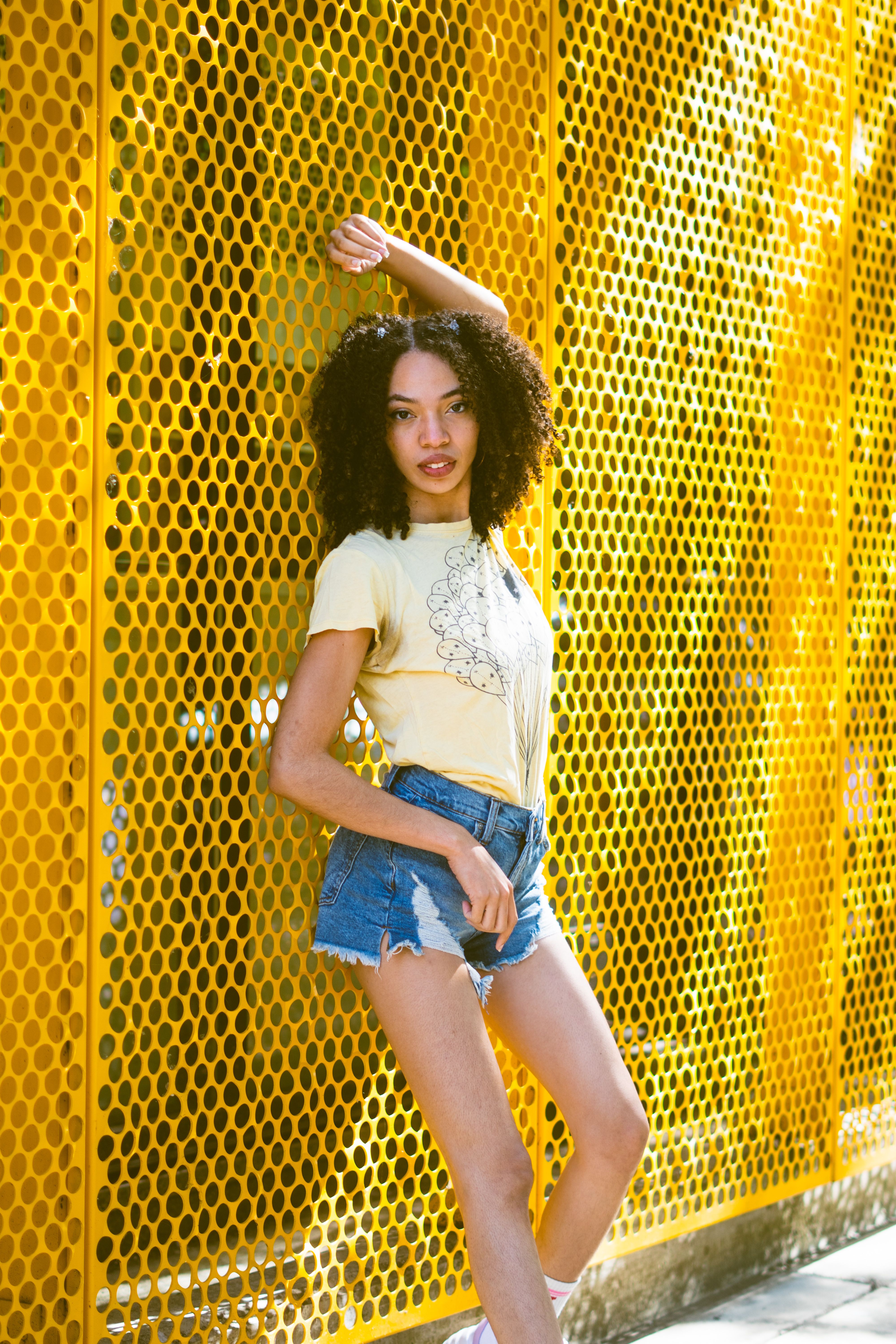 A Woman in Yellow Shirt and Denim Shorts · Free Stock Photo