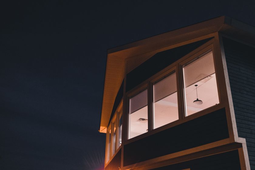 House at nightfall with warmly lit upper windows — photo by Erik Mclean on Pexels