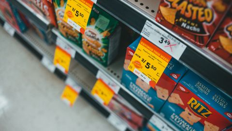 Supermarket aisle featuring discounted snacks with visible sale tags and prices.