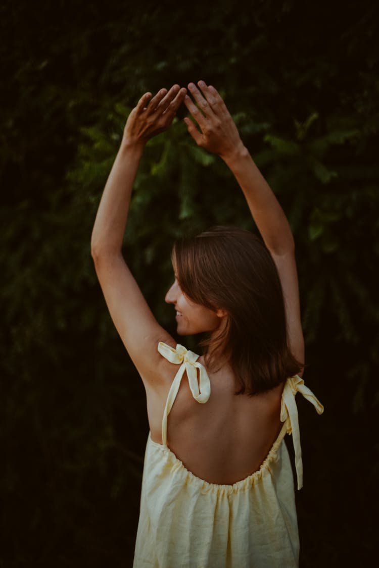 Back View Of A Woman Raising Her Hands