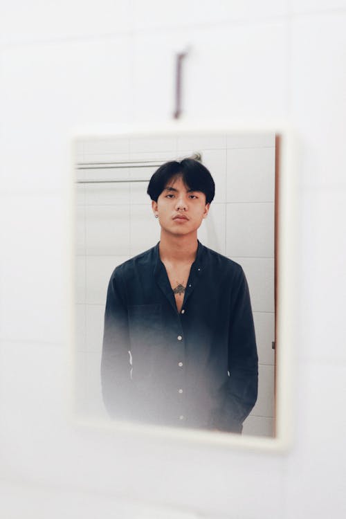 A Reflection of a Man in Black Long Sleeves at the Mirror