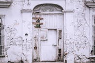 一座白色的古老建筑已经腐朽，门饱经风霜，墙壁也已破裂