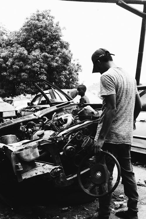 Free Grayscale Photo of Man in T Shirt Holding a Steering Wheel Stock Photo