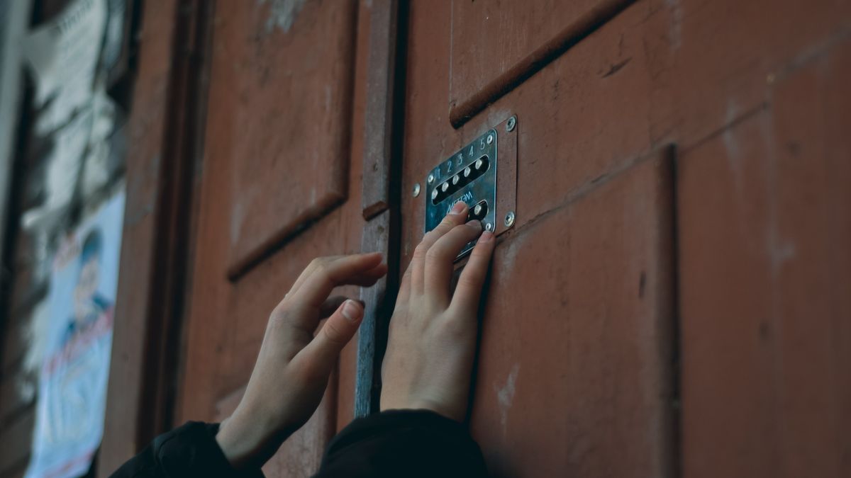 Mains saisissant un code sur le clavier d'une serrure électronique