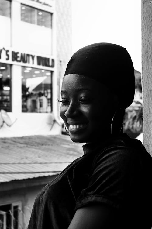 Grayscale Photo of Smiling Woman Wearing a Cap