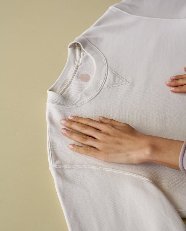 A Person Laying A Shirt Flat On A Surface