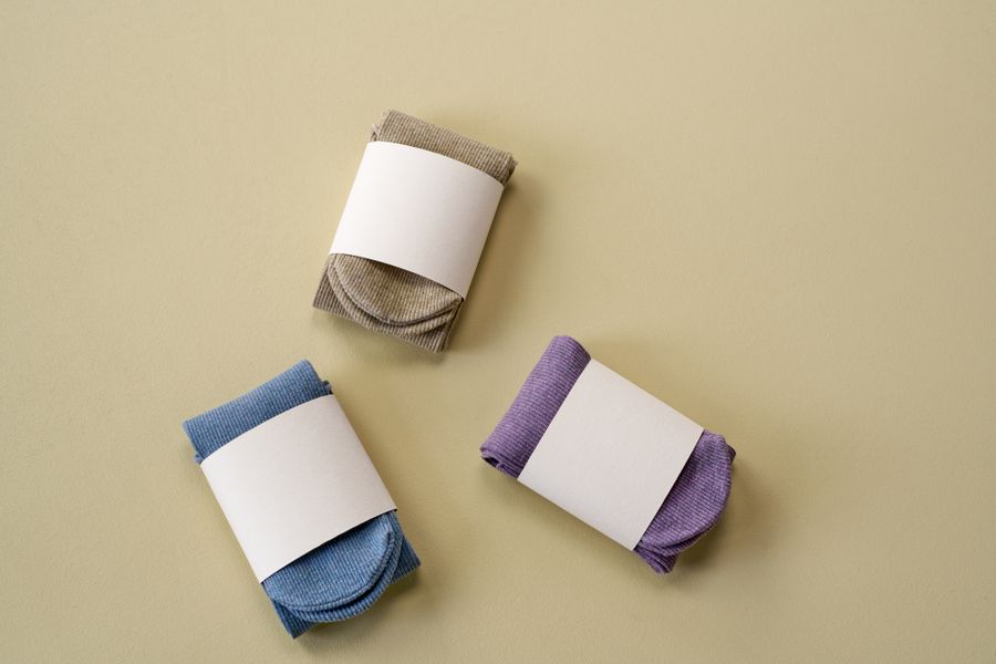 Three folded pairs of crew socks with paper bands — photo by Ron Lach on Pexels