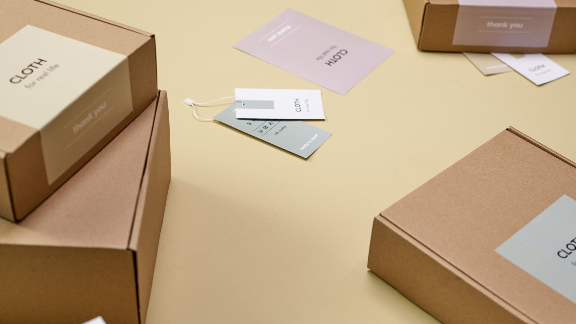 Simple and minimalist cardboard packaging boxes with labels on a yellow surface — package scheme of incentives
