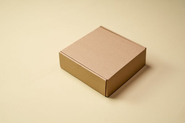 Plain mailer carton on a warm backdrop, photo by Ron Lach on Pexels