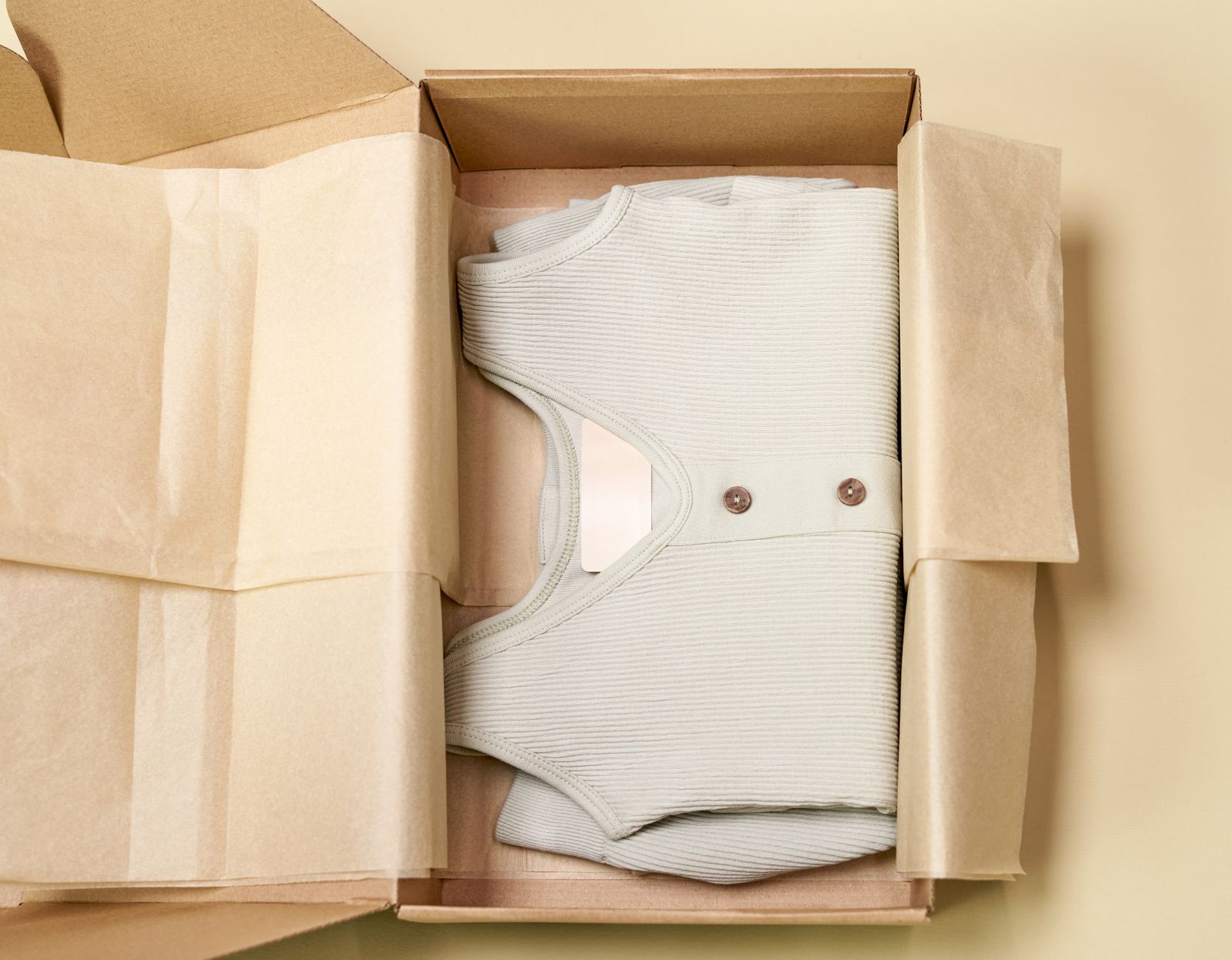 Ribbed cream knit folded into a paper-lined shipping box — photo by Ron Lach on Pexels