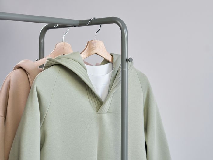 Minimalist sweatshirts displayed on hangers in a studio