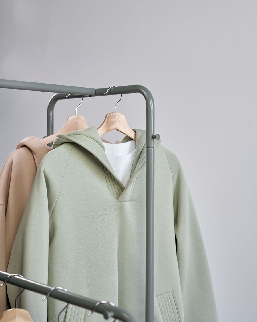 Minimalist sweatshirts displayed on hangers in a studio