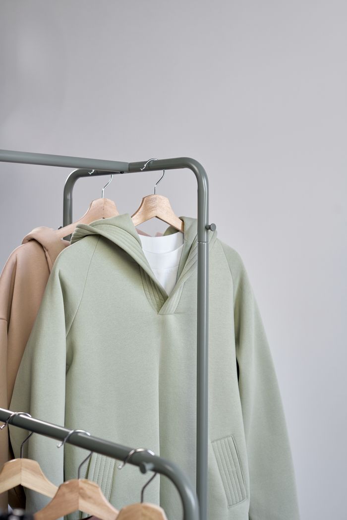Sage hooded sweatshirt on a studio rail, photo by Ron Lach on Pexels