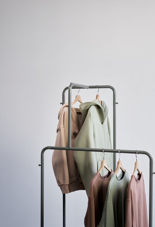 Free Clean and modern clothing rack showcasing minimalist neutral-toned fashion apparel against a white background. Stock Photo