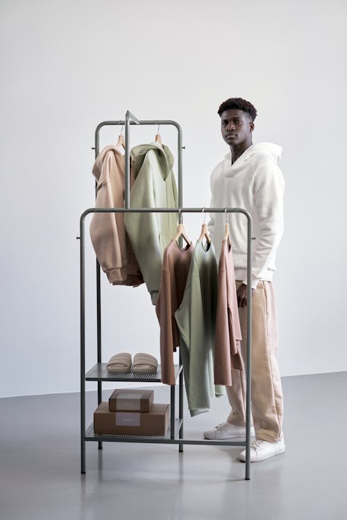 Мужчина стоит возле вешалки для одежды