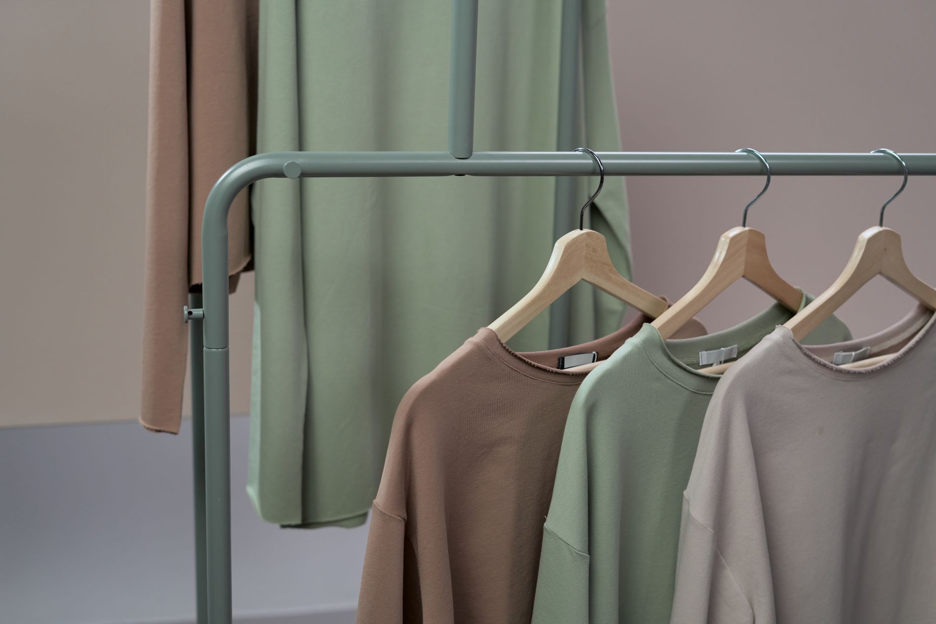 Rows of pared-back knitwear on hangers, echoing the minimalist uniform Everlane sold so well.