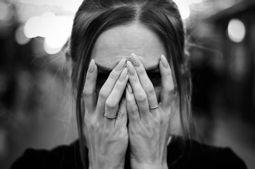 Monochrome Shot of a Woman Covering Her Face with Her Hands