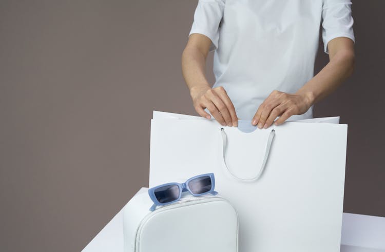 A Person Sealing A Shopping Bag