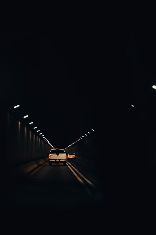 Free A car travels through a dimly lit tunnel, capturing the essence of a moody nighttime road trip. Stock Photo
