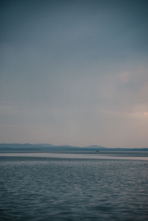 Free Serene ocean view at twilight with gentle waves under a calm sky. Perfect for relaxation themes. Stock Photo