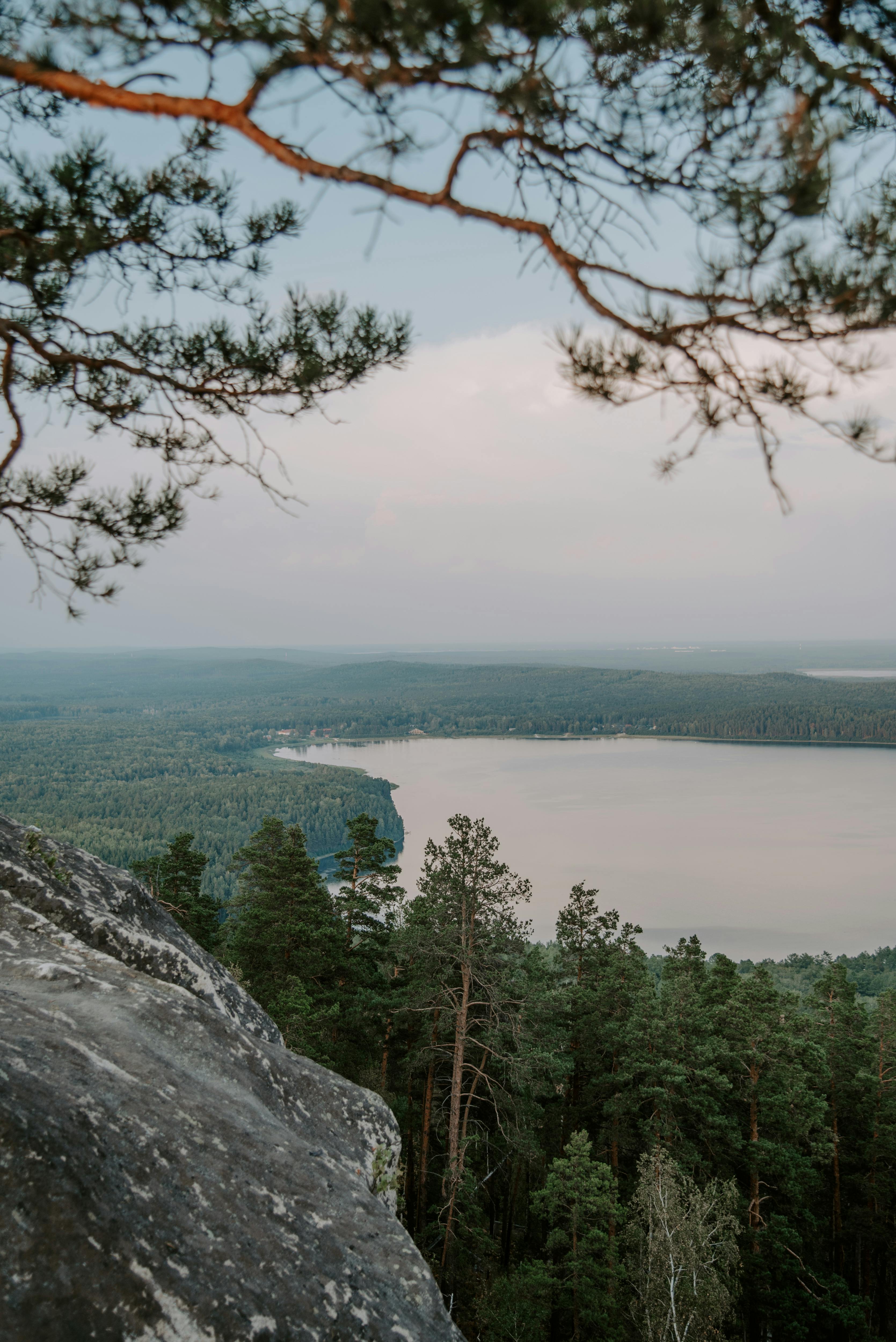 A tranquil landscape with a lake framed by trees and rocks, capturing natural beauty.