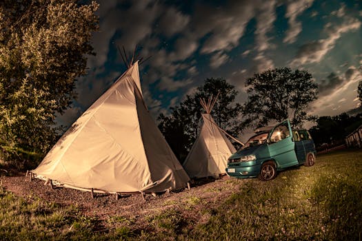 Scenic night view of teepees and a van under a starry sky in Hradec Králové, Czechia.