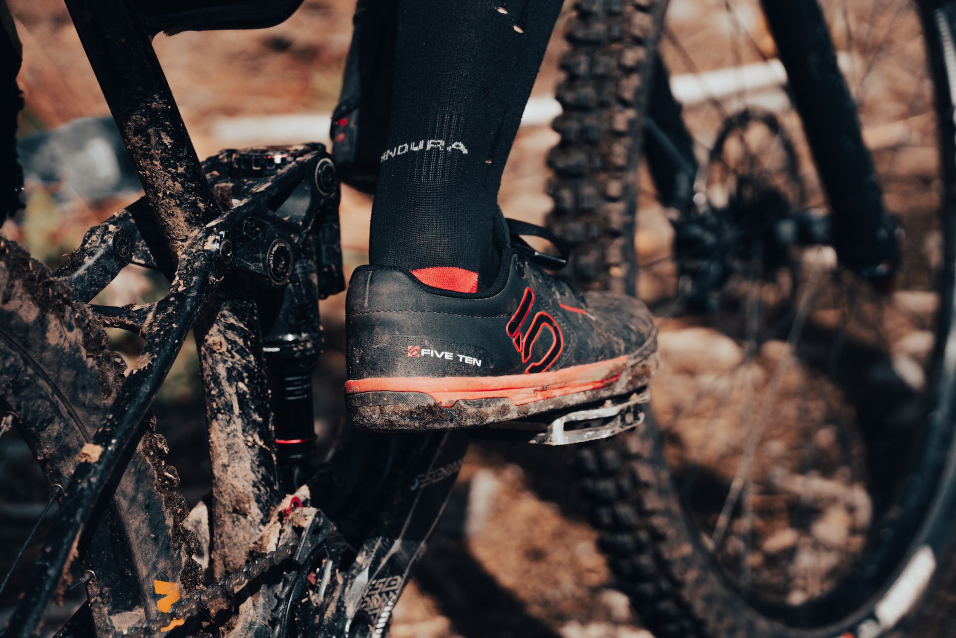 A dynamic shot of a cyclist's shoe on a muddy mountain bike pedal, emphasizing adventure and outdoor biking.
