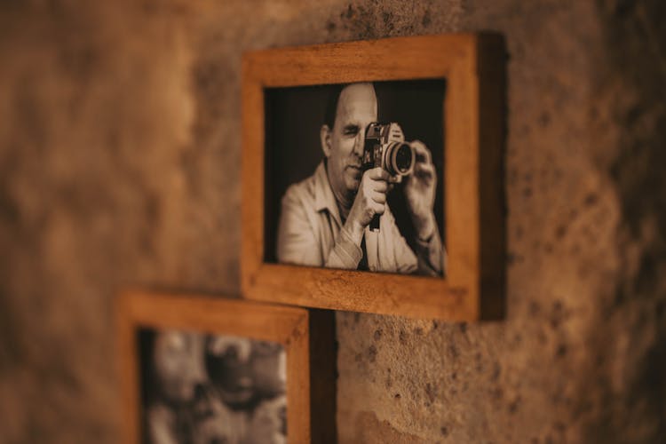 Hanging Photo Of A Man Holding A Camera 