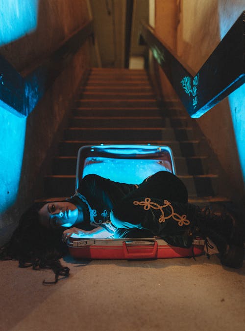 Woman Lying Down on Suitcase