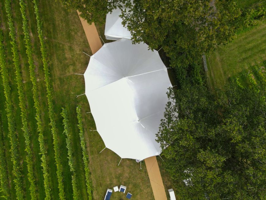 Aerial view of a white event tent set up outdoors in Northern Virginia for a large party