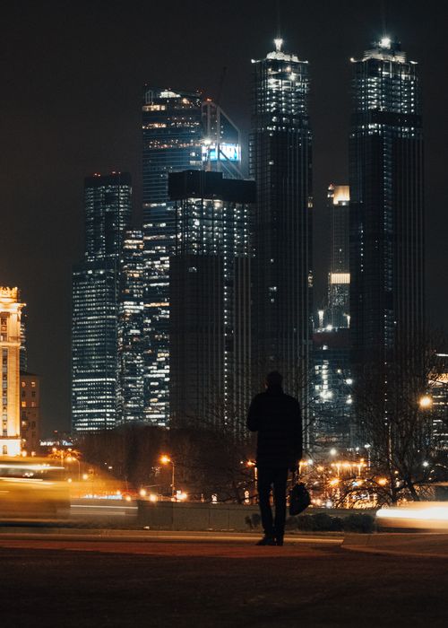 Free Silhouette of a person against the illuminated Moscow skyscrapers at night. Stock Photo