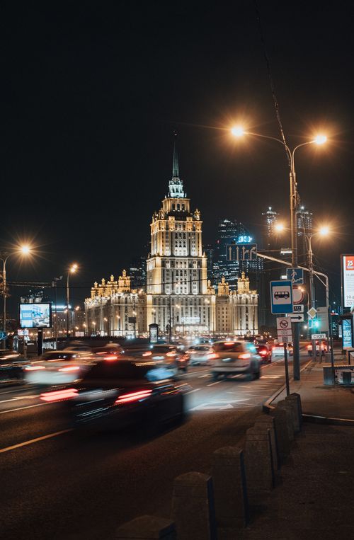 Free Illuminated city streets of Moscow with landmark building and bustling traffic at night. Stock Photo