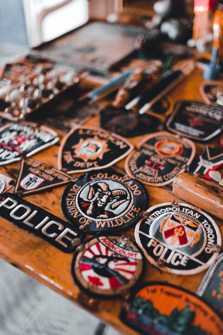 Police Badges On Wooden Surface