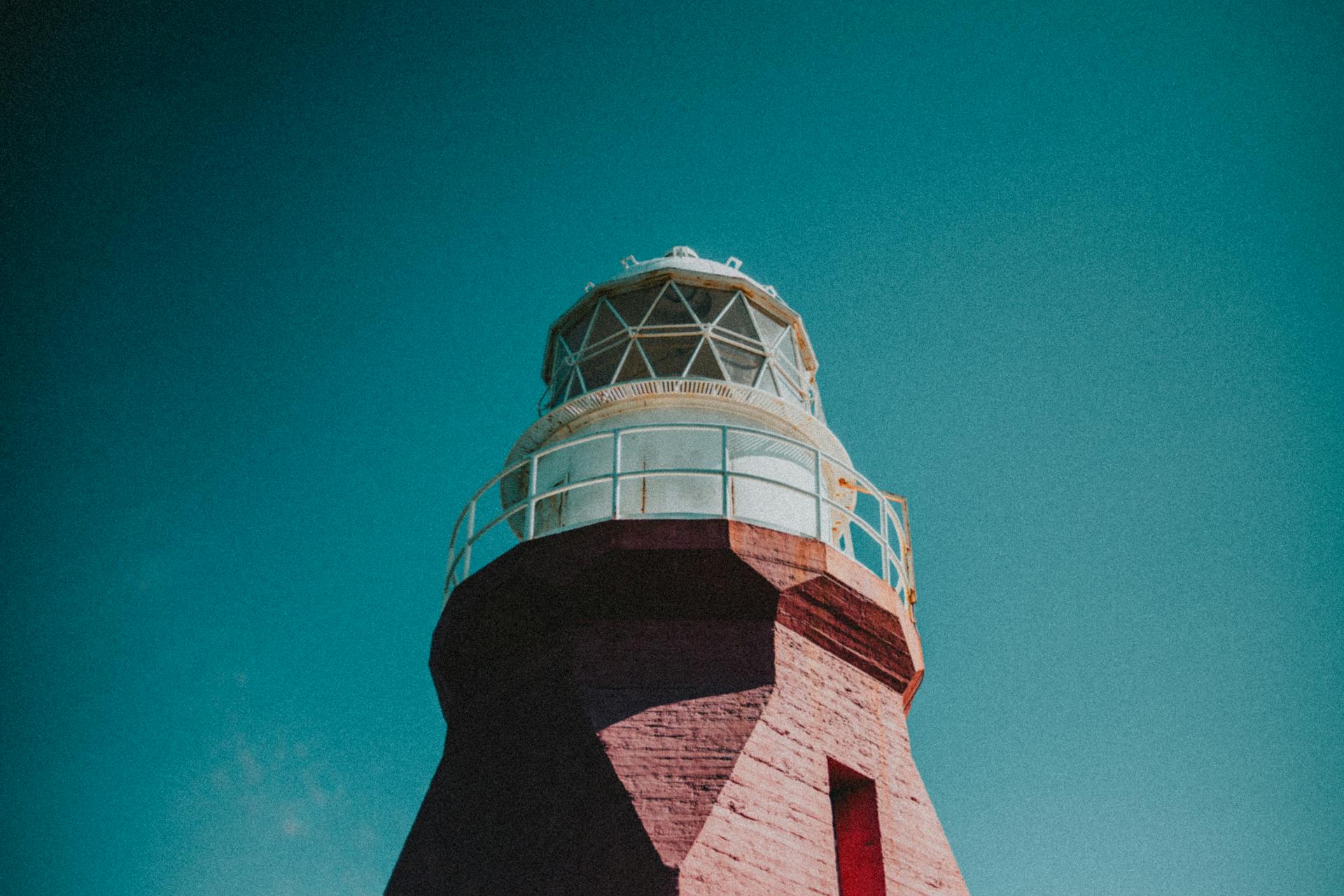 Captivating view of a brick lighthouse against a vibrant sky, showcasing architectural beauty.