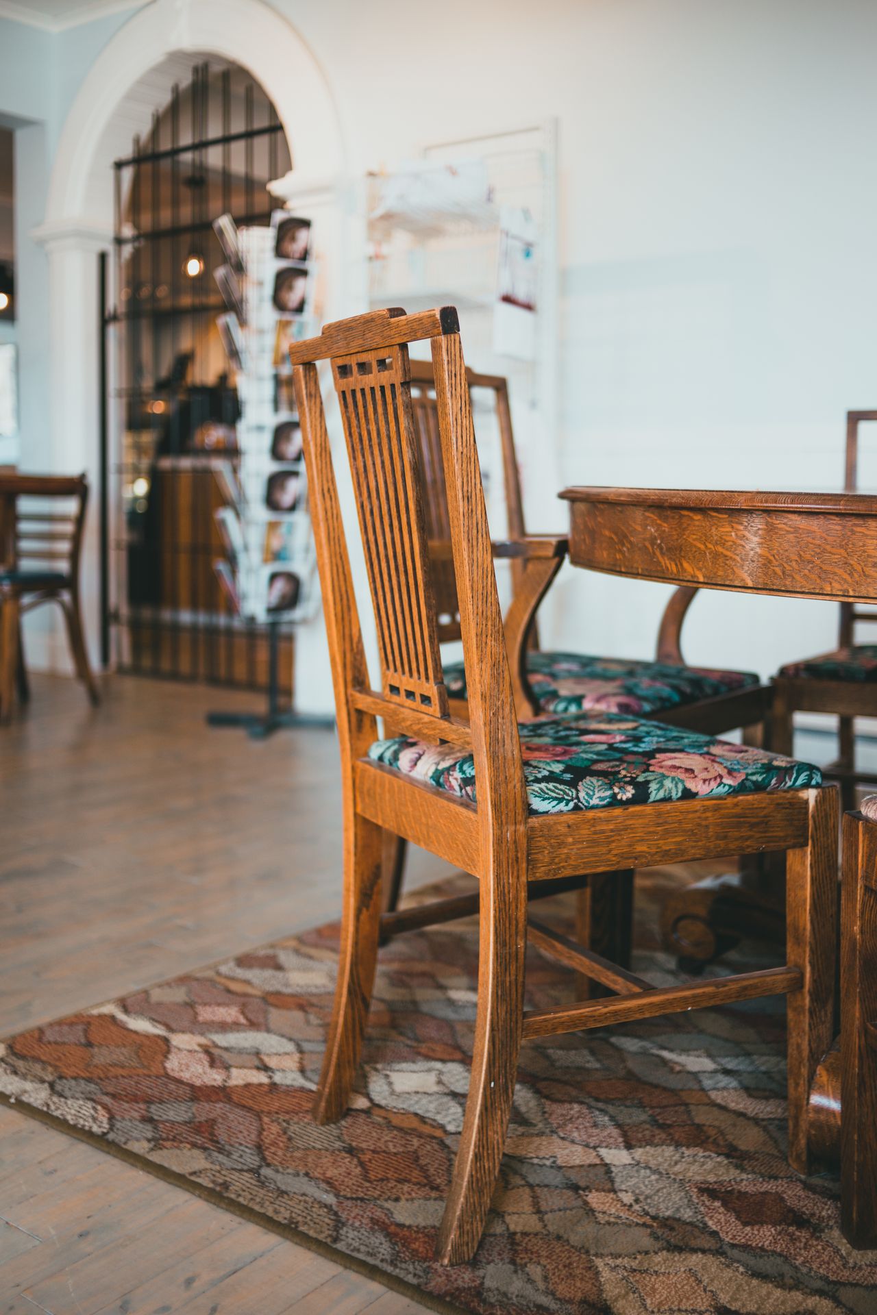 Mission-style oak armchairs with floral cushions around a round wooden table