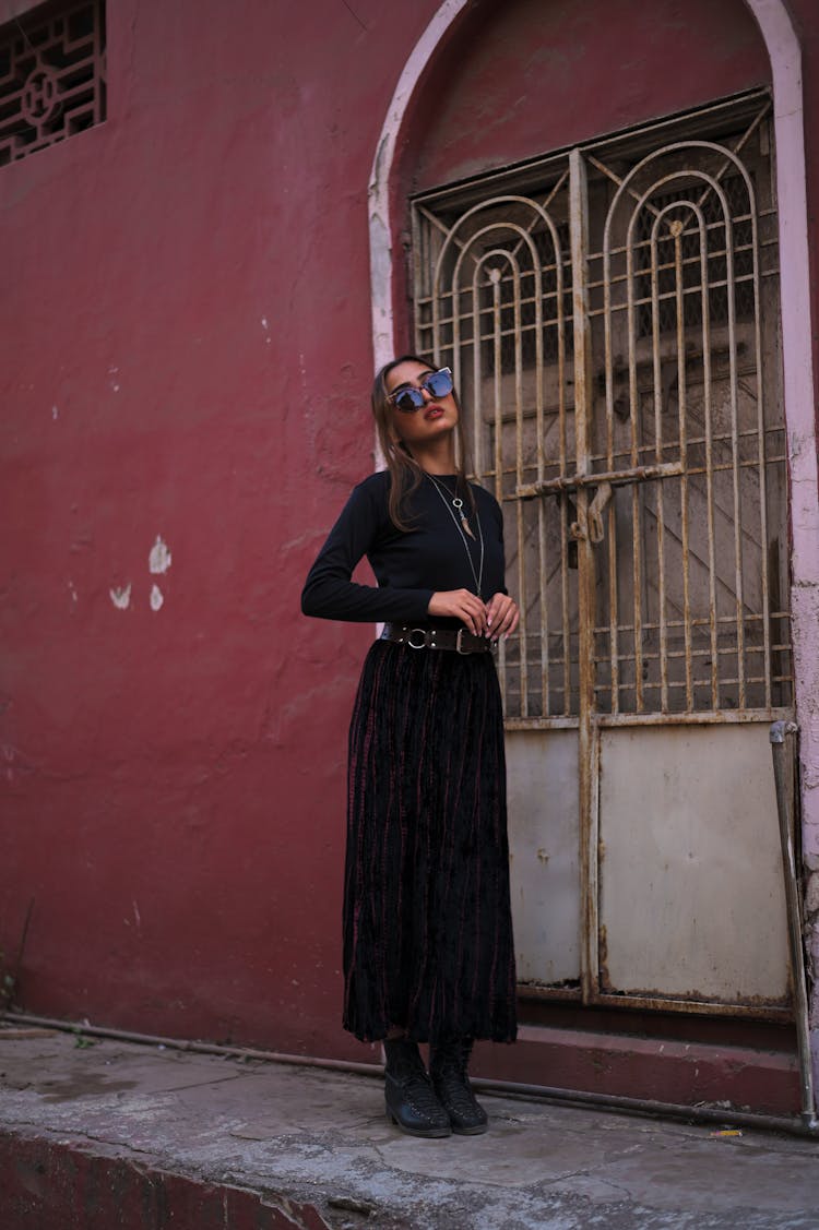 Woman Dressed In Black Standing On A Street 