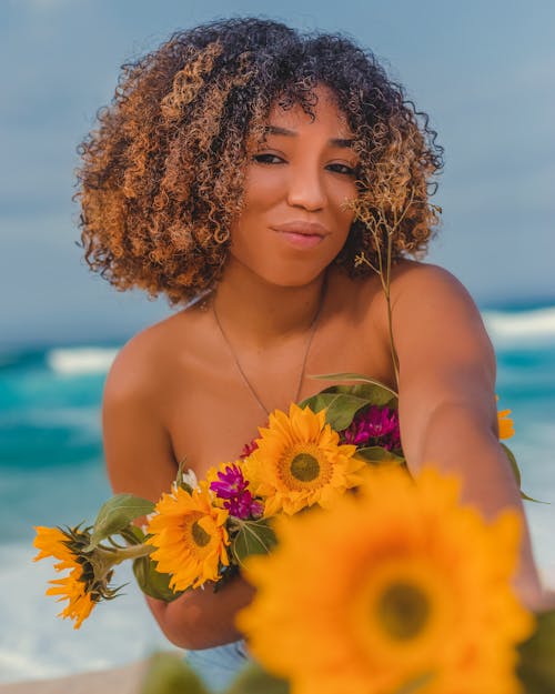Woman On Beach Holding Flowers