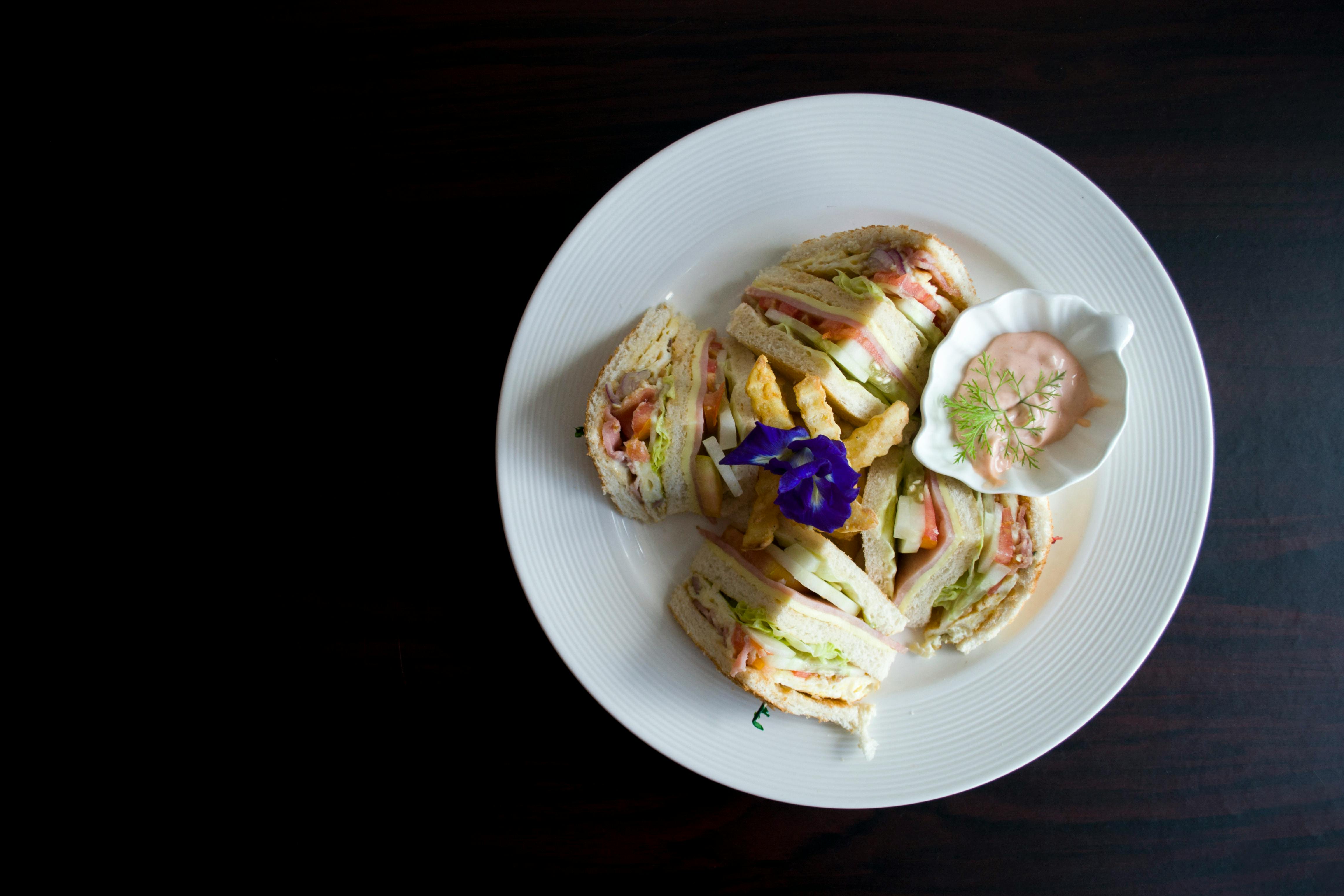 sliced clubhouse on round white ceramic plate