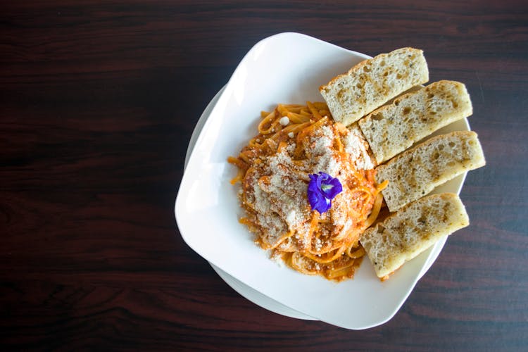 Photography Of Pasta With Garlic Bread