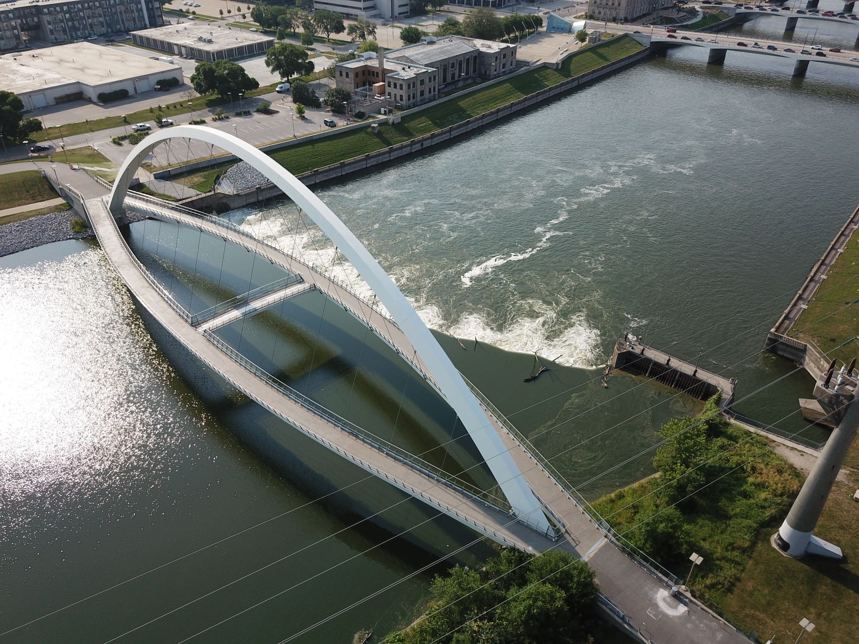 Aerial image capturing a modern bridge over the river in Des Moines, Iowa, USA.